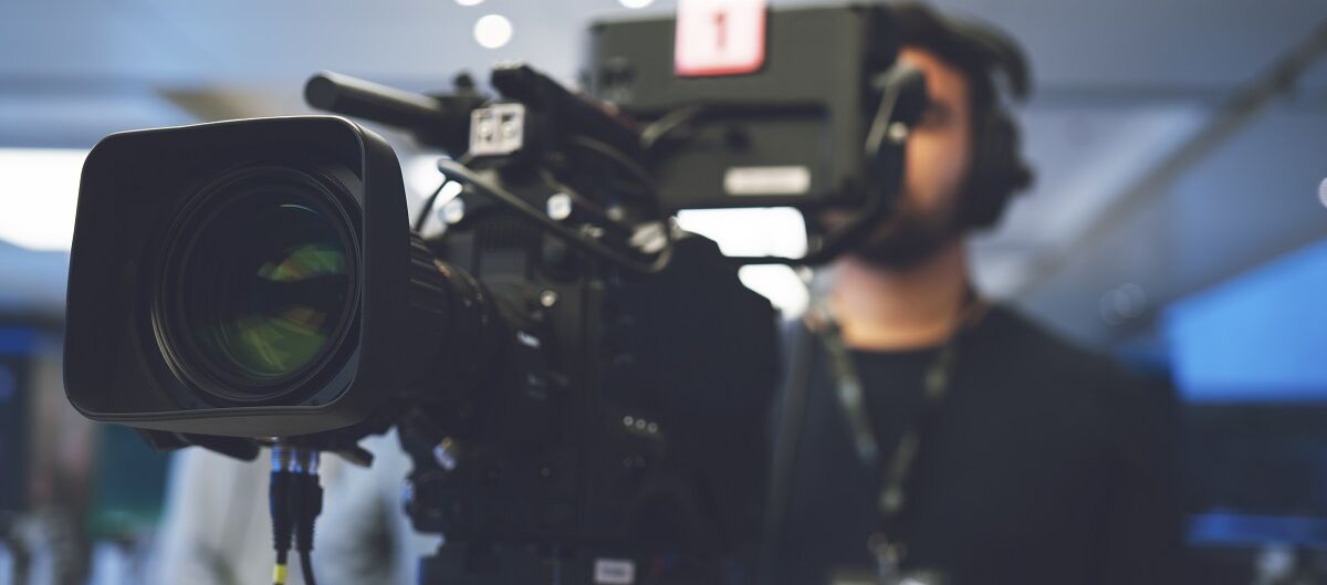 Mann filmt mit einer Fernsehkamera