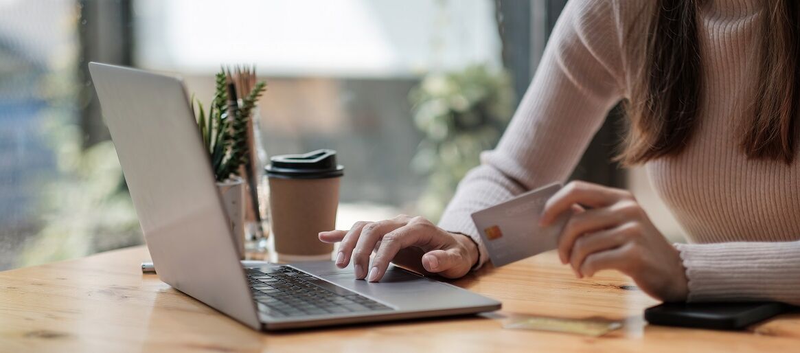Frau im Cafe zahlt per Online Banking