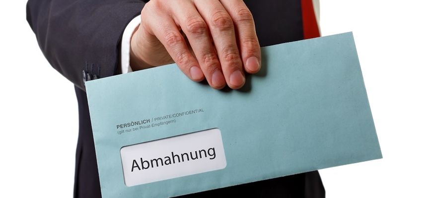Hand mit Brief mit Aufschrift Abmahnung
