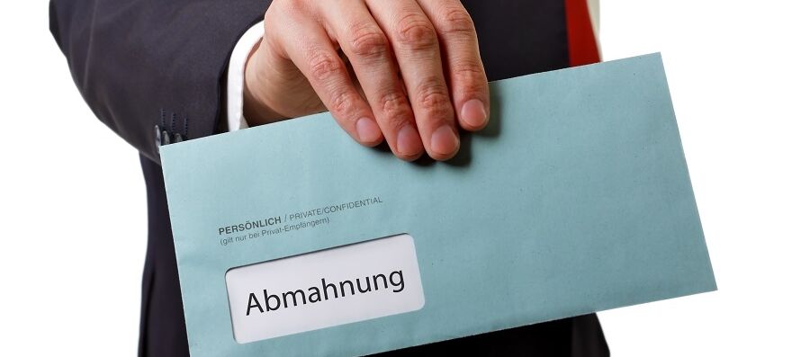 Hand mit Brief mit Aufschrift Abmahnung