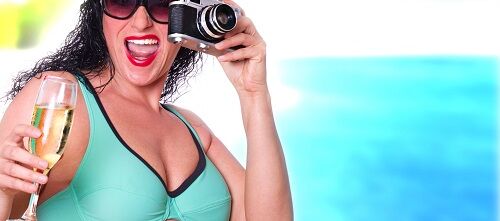 Frau mit Kamera im Strandurlaub