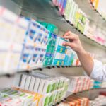 Apotheker nimmt Medikament aus dem Schrank