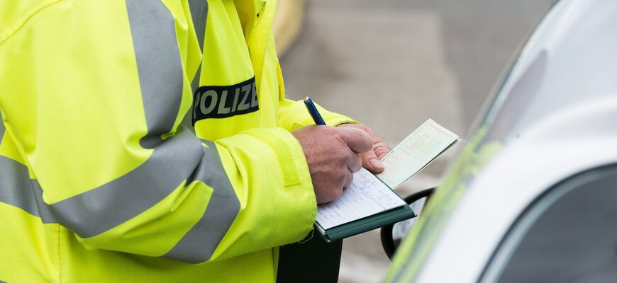 Polizist füllt Bescheid wegen Falschparken aus