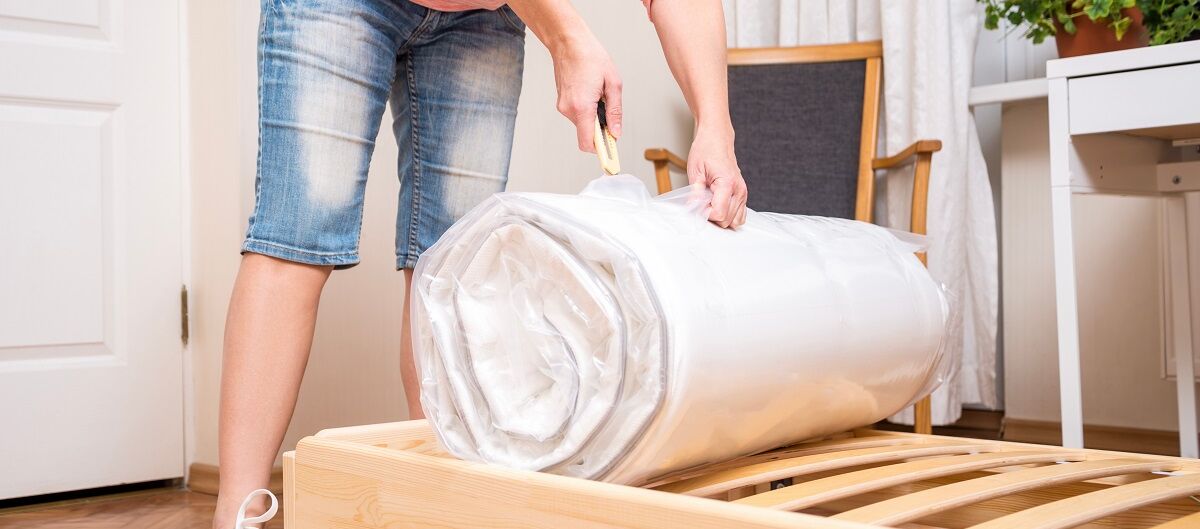 Frau rollt neue Matratze aus