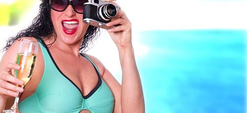Frau mit Kamera im Strandurlaub
